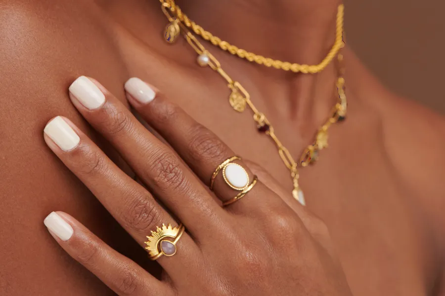 Main avec bague et collier doré